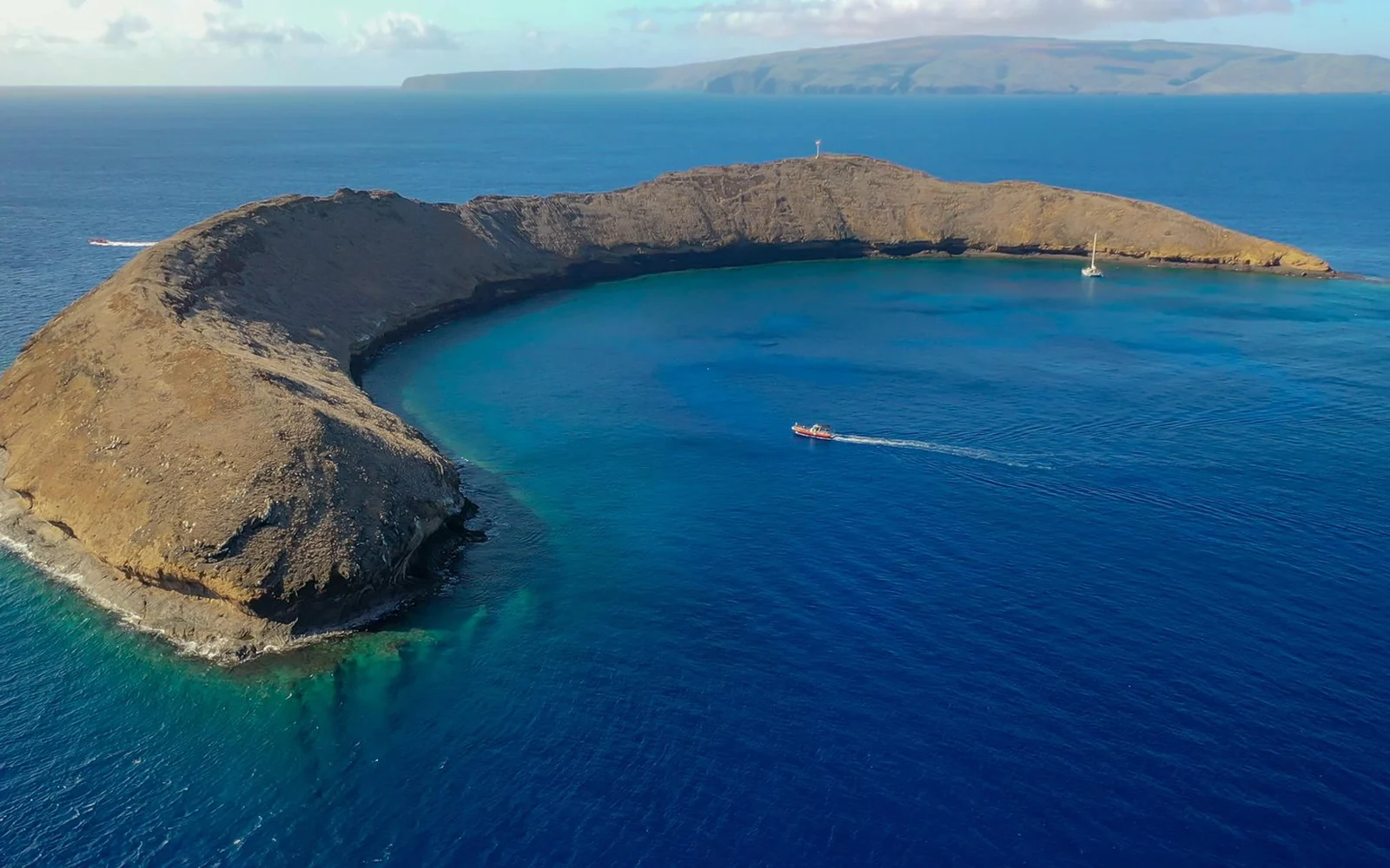 El borde curvo y marrón de Molokini visto desde el aire, con el océano azul profundo alrededor